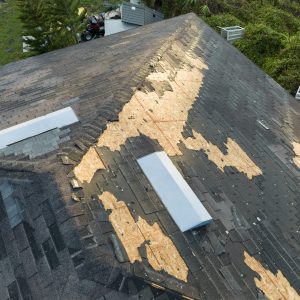 Damaged house roof with missing shingles after hurricane Ian in Florida. Consequences of natural disaster.